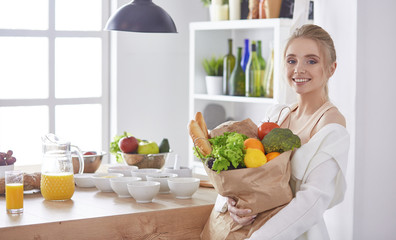 Young woman holding grocery shopping bag with vegetables Standi