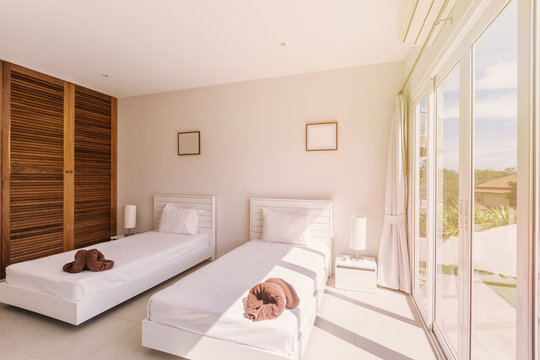 Modern bed room interior in Luxury villa. White colours, big window, two beds