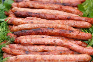 Grilled pork meat sausages with green condiments