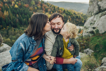 Young family with little son spending time together outside.