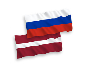 National vector fabric wave flags of Latvia and Russia isolated on white background. 1 to 2 proportion.