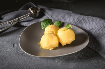 Mango ice cream sorbet with mint leaves on rustic background