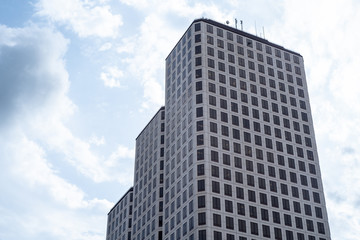 Fototapeta premium Low Angle Of Modern Glass Skyscraper Against Vivid Blue Sky with Clouds