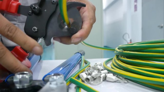 Electrician cutting cable by using cutting pliers