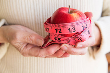 hands with apples and tape measure, concept of diet and weight control.