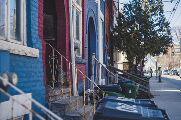 Fototapeta na wymiar Alternating Red and Blue Houses Along Sidewalk Shallow Angle