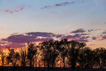 Landscape with bloody sunset. The terrain in southern Europe. Tragic gloomy sky. Purple-magenta clouds.