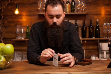 Bearded hipster bartender playing with his trick cards.