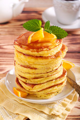 Pile of pancakes with honey on plate