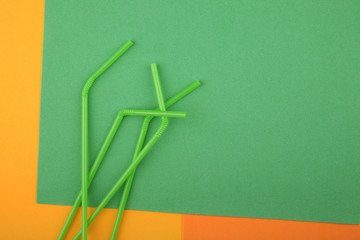 Drinking straws on green background. Summer cocktail party, fun and happy vacation concept.