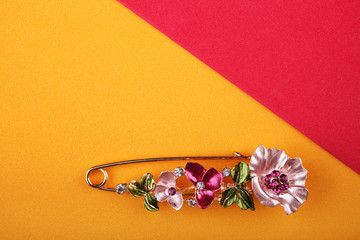 Beautiful brooch with flowers on a orange background