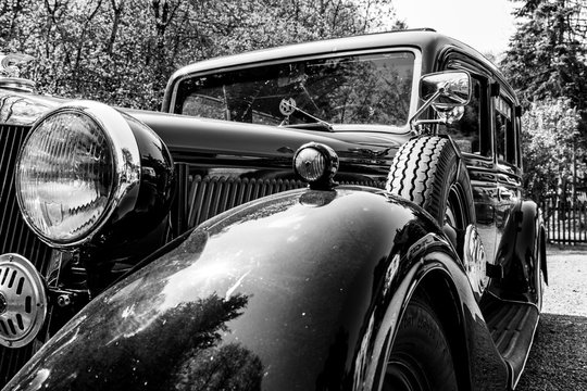 Oldtimer, Seintenansicht mit Reserverad in schwarz-wei&szlig;.
