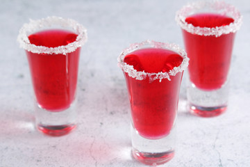 Three cranberry liquor shots with whole berries
