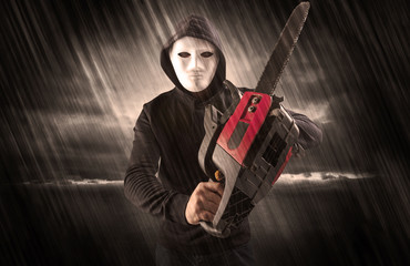 Masked armed poacher in mysterious rainy coastal weather concept
