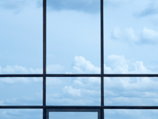Window frame and blue sky with clouds. Outside the office window.