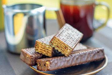 Cup of coffee, chocolate waffles and a jug of milk