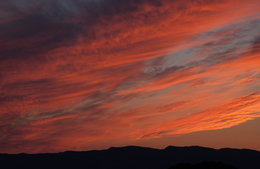 Beautiful evening sky. Clouds lit up in fiery red by the setting sun.