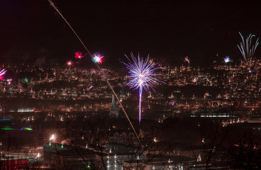 Fototapeta na wymiar New year's eve fireworks over a dark town.