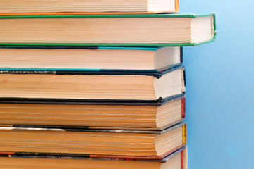 Old and used hardback books or text books seen from above. Books and reading are essential for self improvement, gaining knowledge and success in our careers, business and personal lives