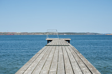 Obraz premium Wooden pier with a spring board waiting for the summer to arrive.