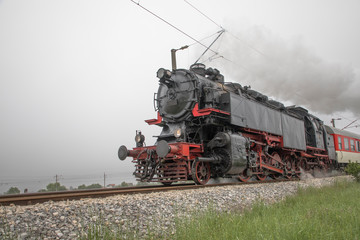 Retro vintage steam locomotive on rail tracks