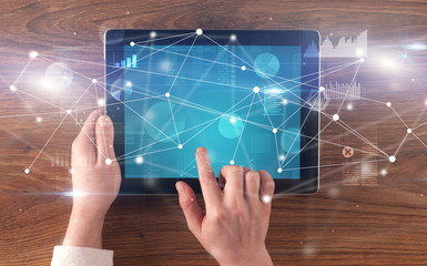 Hand using tablet with linking graphs charts  report and informational flow concept
