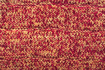 Sweater or scarf fabric texture large knitting. Knitted jersey background with a relief pattern. Wool hand- machine, handmade, red,