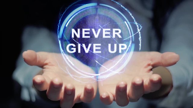 Female hands show a round conceptual hologram with text Never give up. Unrecognizable woman in ashen white on a black background with future holographic technology