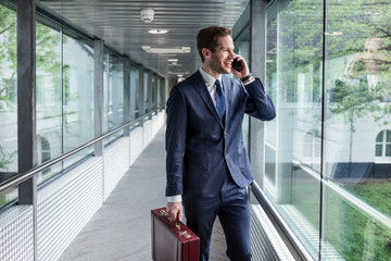 Erfolgreicher Business Mann - glücklicher Unternehmer - Mitarbeiter telefoniert im Anzug