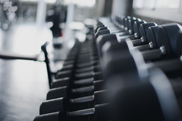 Dumbbells set in fitness club, weights equipment, selective focus, equipment in gym.