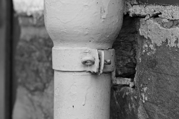 A detail of a screw of a white downpipe (Germany, Europe)