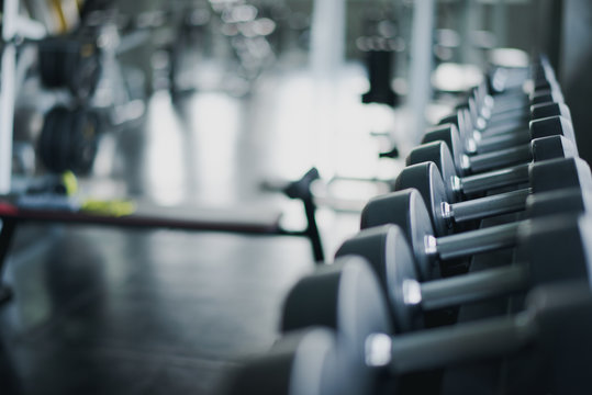Dumbbells set in fitness club, weights equipment, selective focus, equipment in gym.