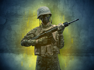 Fototapeta premium Hazard, menace soldier in a ruined crumbly building with arms on his hand 
