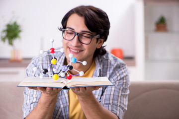 Young student physicist preparing for exam at home    