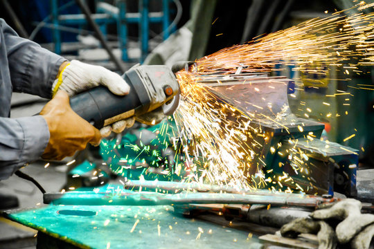 Worker are grinding metal steel, Electricity spark from chainsaw, Technician are cutting pipe, Risk work for electricity in factory