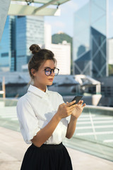 Young businesswoman in the city with modern buildings