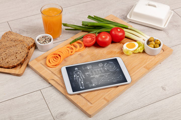Healthy food composition with tablet. Body diagnosis on the screen