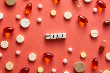 Black and white title PILL from white cubes on the table with tablets on coral background