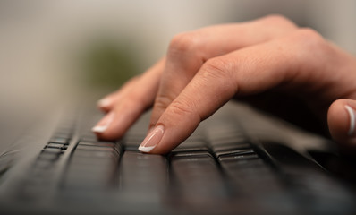 Hand typing on keyboard with office concept
