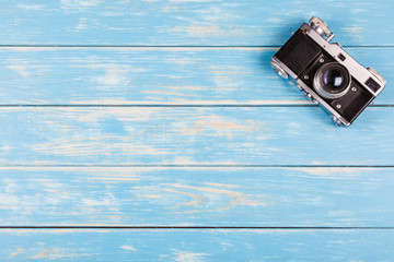 Old camera on a blue wooden background