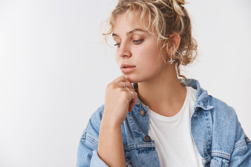 Tenderness, lifestyle fashion concept. Sensual good-looking blond curly-haired scandinavian female turn left look down thoughtful, touch chin thinking, show perfect skin promote cosmetology salon
