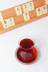 Turkish tea in a glass cup on the background of a Turkish table game okey