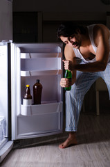 Man breaking diet at night near fridge