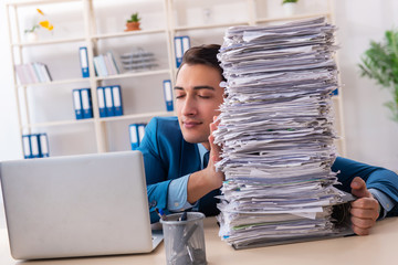Young handsome businessman unhappy with excessive work 