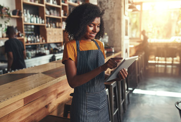 Female owner using digital tablet in cafe