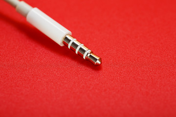 White connector AUX white cable on a red background