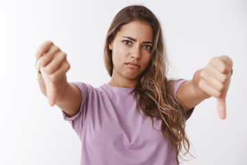 Girl reacting awful bad idea, showing thumbs down grimacing disapproval, disagree disliking stupid...