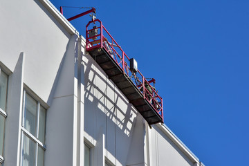 Specially equipped cradle on the facade of the building. Moves vertically along the facade to perform repairs and clean the building.