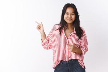 Woman suggesting friends hit bar and have fun pointing left as inviting move that direction smiling...