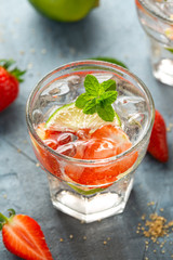 Strawberry Mojito cocktail with Rum, lime and mint in glass. Summer cold drink with ice